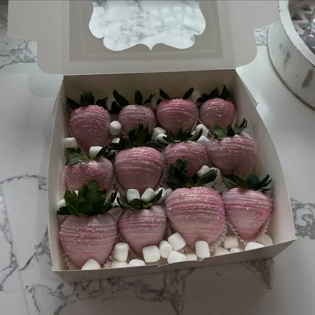 Pink chocolate covered strawberries in a bakery box
