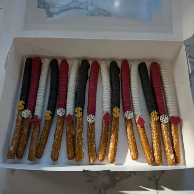 Chocolate covered pretzel rods and strawberries in a gift box