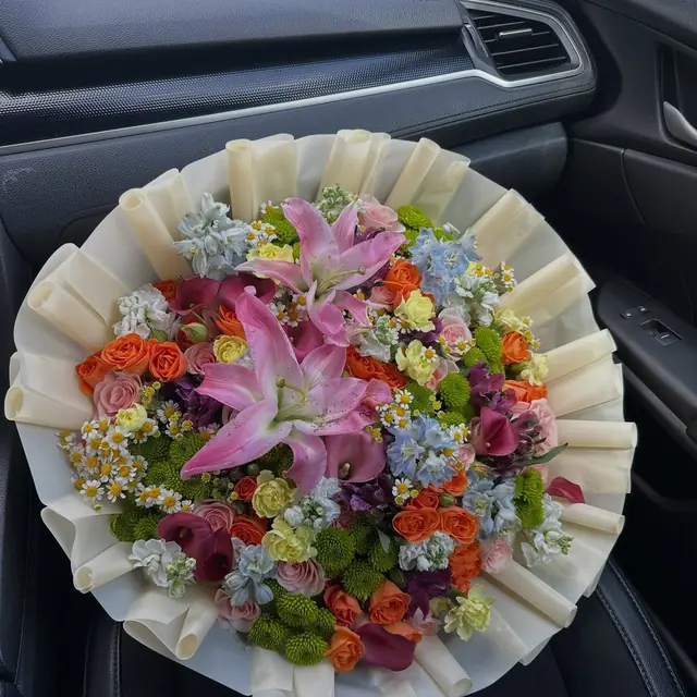 Bright mixed bouquet of lilies, roses and wildflowers