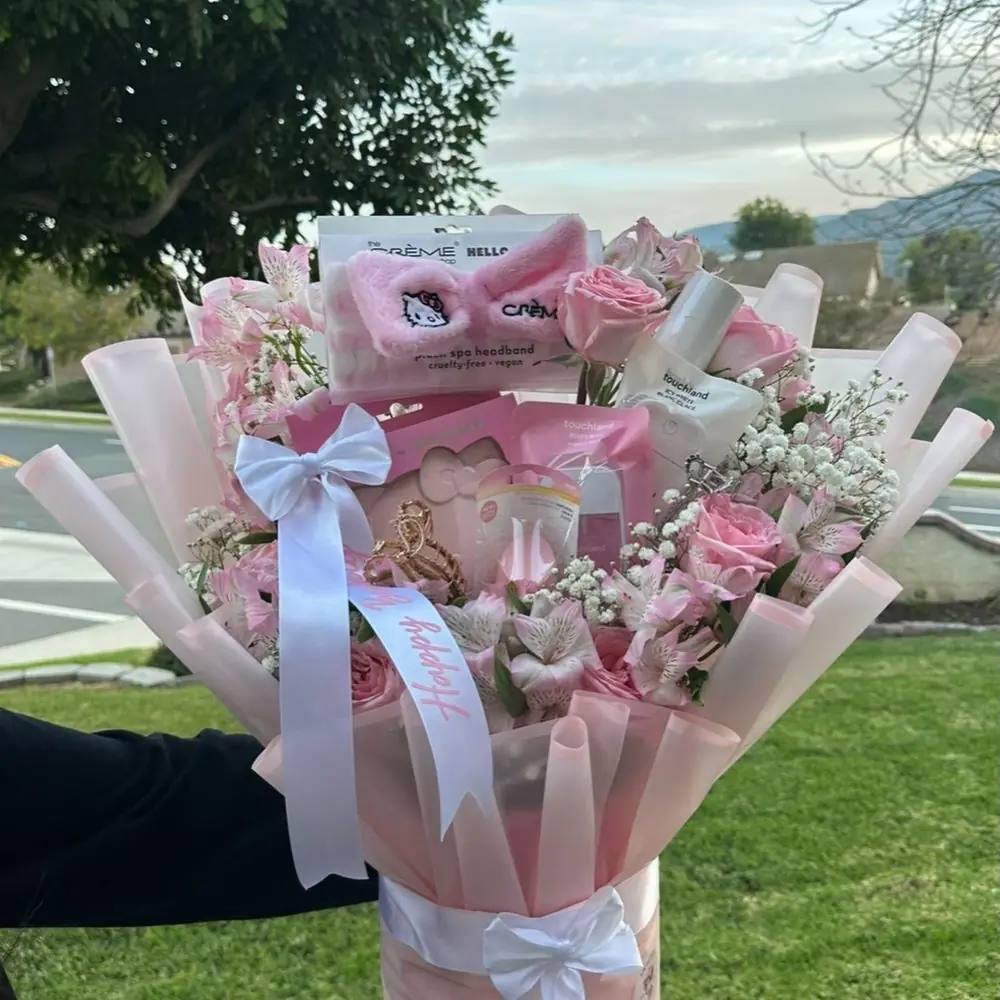 A blush bouquet and dipped strawberries held up outdoors
